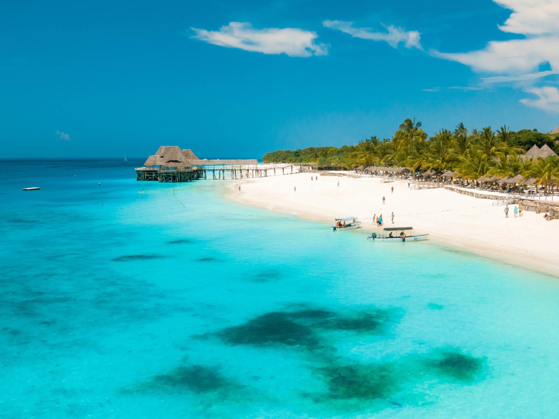 Plage de Zanzibar avec eau turquoise et bungalow sur pilotis